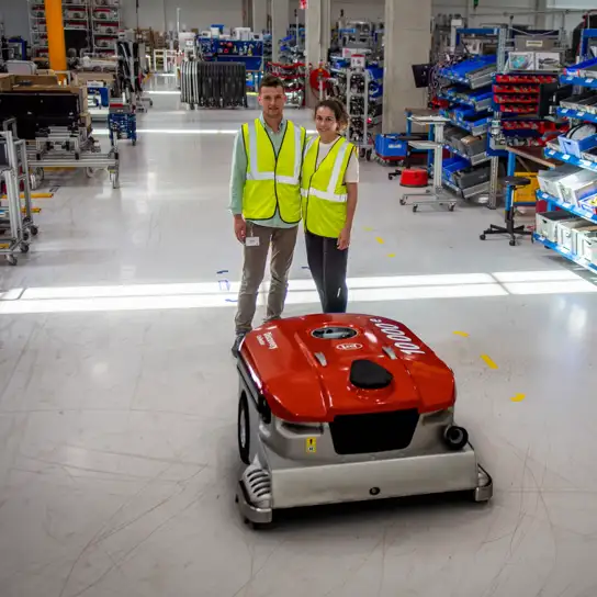 Lely Collector Numer 10.000 in der Produktion mit zwei Lely Mitarbeitern.