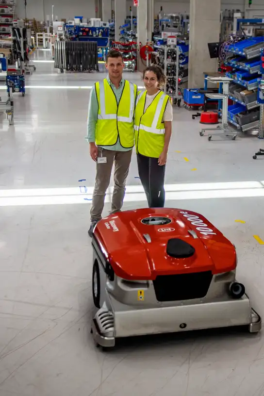 Lely Collector Numer 10.000 in der Produktion mit zwei Lely Mitarbeitern.